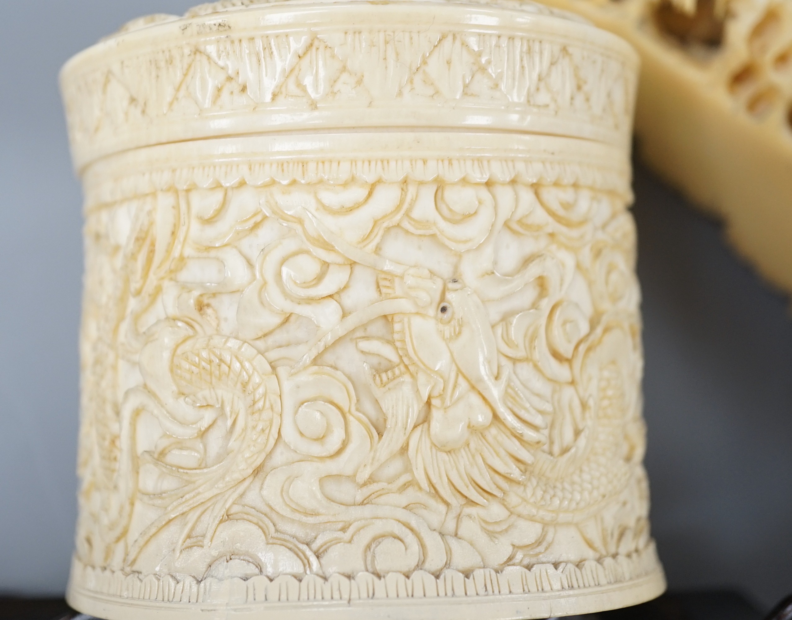 An early 20th century Chinese ivory ‘dragon’ box and cover, and a boar’s tusk carving of figures amid pavilions 40cm